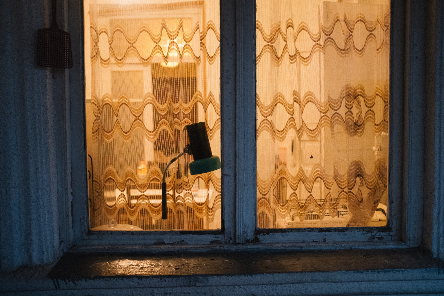 Window with a lamp in old Soviet house in Georgia