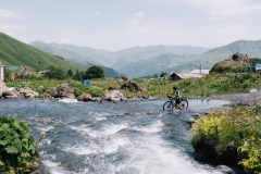 Crossing a river on a bicycle in Roshka, Georgia