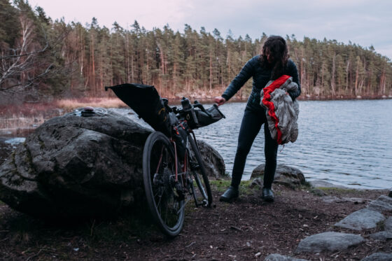 Sabina pulling her Sea to Summit sleeping bag out her Apidura handlebar bag