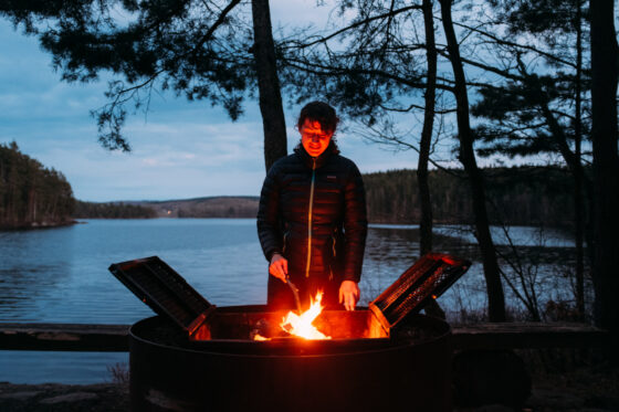Sabina warming up campfire bikepacking wind shelter Sweden