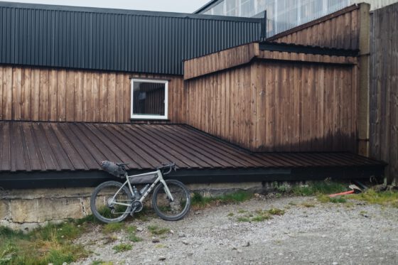 Robin's gravel bike parked against the old unattractive station made of wooden boards