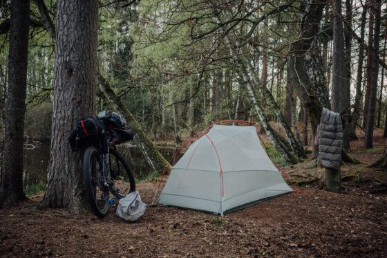 Minimalist bikepacking camping setup with tent, bike and gear