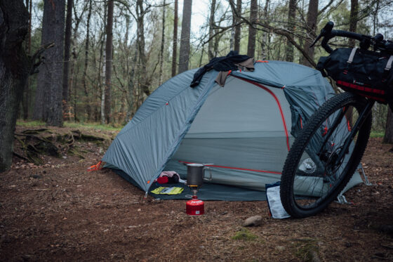 Minimalist bikepacking camping setup with tent, bike and gear