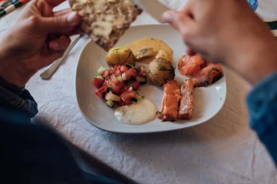 Traditional Swedish Midsommar meal with new potatoes, pickled herring, and salmon
