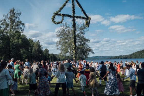 Traditional Midsommar celebration in Fengersfors with people dancing around the maypole