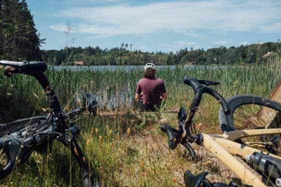 Cyclist taking a break by a lake in Dalsland, Sweden — bikes resting in the foreground