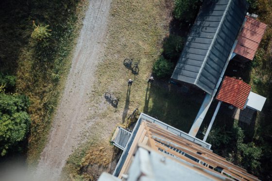 Aerial view of bikes and riders resting beside a lookout tower in the Harz Mountains.